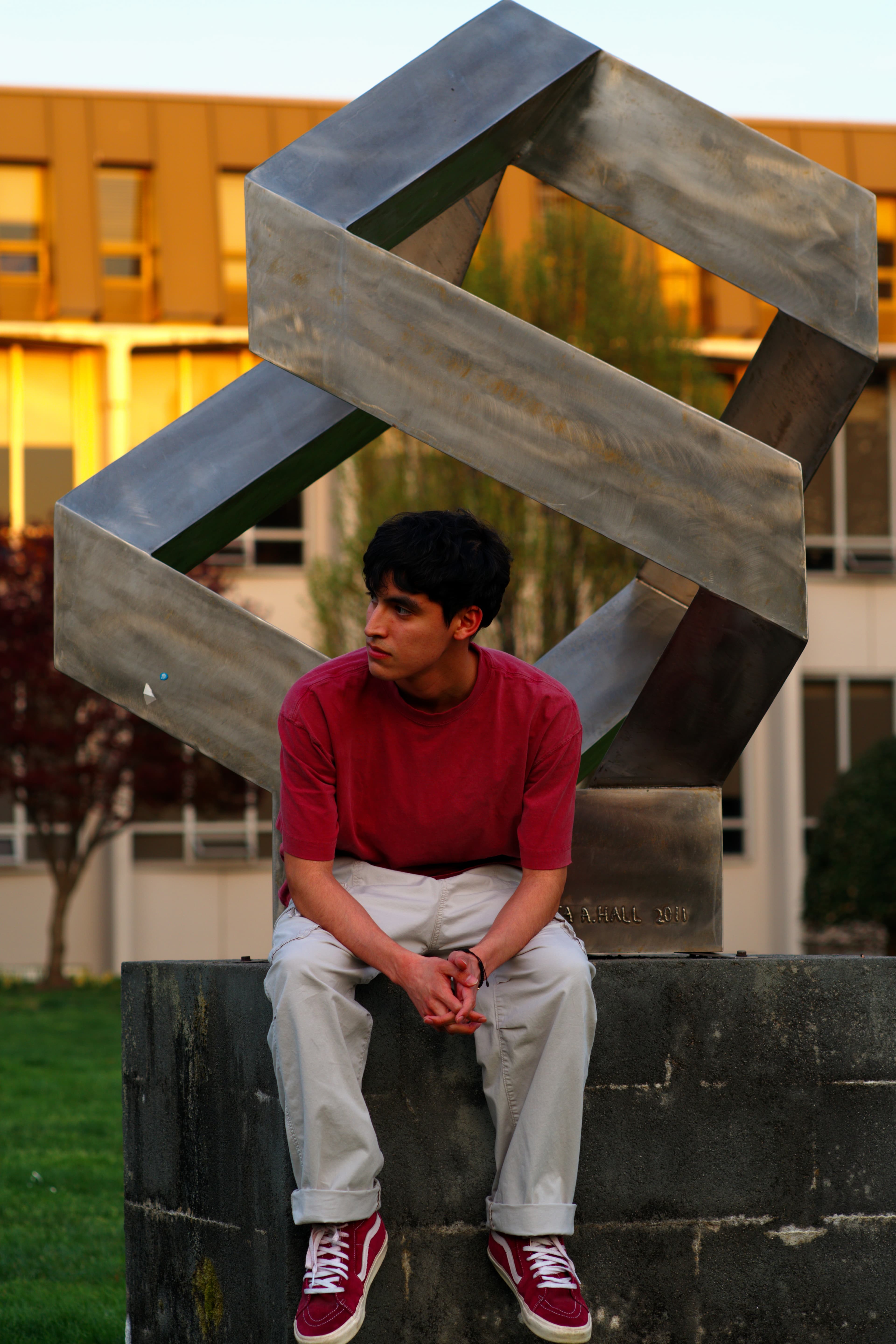 Portrait in front of geometric campus sculpture at golden hour